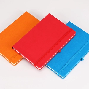 Classic hardcover notebooks with elastic straps in vibrant red, blue and orange colors