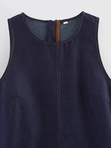 Close-up of sleeveless denim dress featuring orange contrast stitching and S-size label