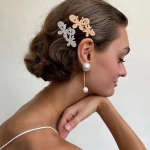 Hollow butterfly hair clips and pearl drop earrings shown on a professional model