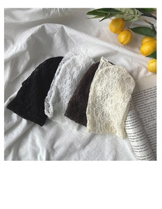 Dettaglio in piano di berretti in pizzo floreale nei colori nero, bianco e caffè
