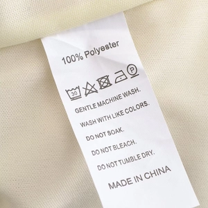 Détail de l'étiquette d'entretien en polyester avec icônes de lavage sur la robe longue
