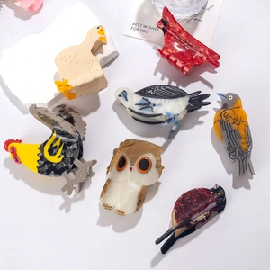 Collection of animal-shaped acetate hair claws including flamingos, owls, and parrots