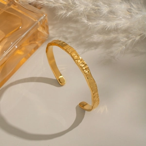 Détail du bracelet jonc plaqué or 18 carats avec texture martelée et éclat métallique