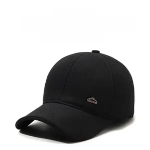 Detail view of winter wool baseball cap with warm ear flaps and metal mountain logo