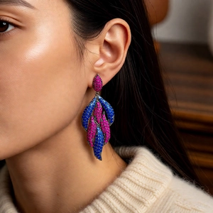 Detail of vintage teardrop earrings with pink and blue stones on a model