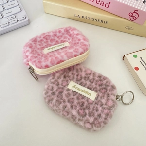 Dettaglio di pochette in peluche leopardato rosa e grigio con cerniera ad anello argento