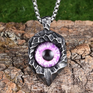 Detail of purple evil eye pendant on bark background showing S.Steel engraving