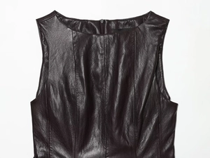 Gros plan du haut en similicuir marron foncé montrant la texture et le zip au dos