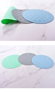 Detailed view of circular silicone heat-resistant mats in green, gray, and blue colors