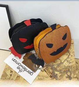 Detail of pumpkin crossbody bags in matte black and glitter orange with bat wing accents