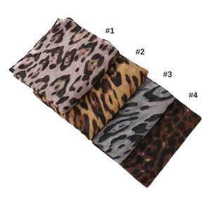 Flat lay of four lightweight leopard print scarves in beige, yellow, gray and brown