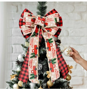 Detail of Christmas tree topper bow with red truck print and merry christmas text