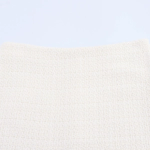 Detailed close-up of white tweed fabric texture on a two-piece sweet style women's suit set