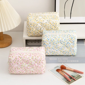 Three-piece quilted floral cosmetic bag set in pink blue and yellow for travel storage
