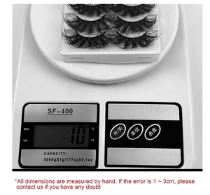 Close-up of 5 pairs of thick false eyelashes being weighed on a digital scale