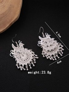 Detail view of silver hollow peacock earrings with bells, measuring 6.5cm by 4cm