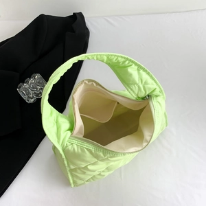 Top view of neon green quilted nylon shoulder bag showing interior beige pocket and zipper