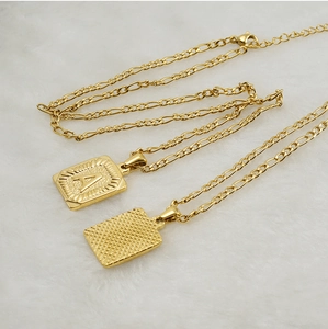 Detail of 18K gold-plated square initial pendant with A letter and grid pattern on Faro chain