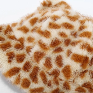 Detailed macro view of soft faux fur plush material with leopard print pattern and texture