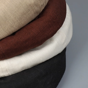 Gros plan sur la texture du lin des casquettes en kaki, marron, beige et noir