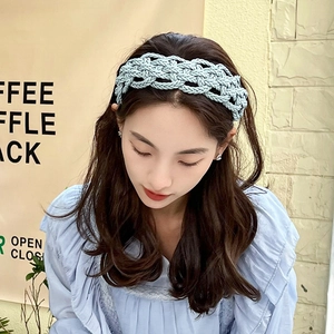 Close-up of light blue braided rope headband with intricate hollow mesh texture and woven detail