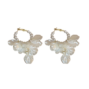 Elegant gold hoop earrings with white pearls and hanging petal tassels on white background