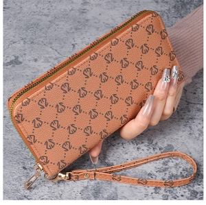 Détail d'un portefeuille en cuir orange marron avec motif gaufré et dragonne assortie