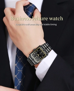 Montre d'affaires avec lunette carrée dorée et bracelet en acier noir sur costume