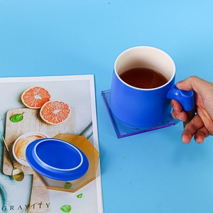 Detailed view of handmade square floral resin coasters with blue ceramic mug and silicone mold