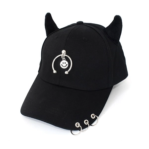 Detail of black baseball cap featuring devil horns and metal rings with a smiley pendant