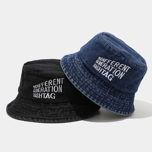 Black and blue denim bucket hats with embroidered lettering shown from a top-down view