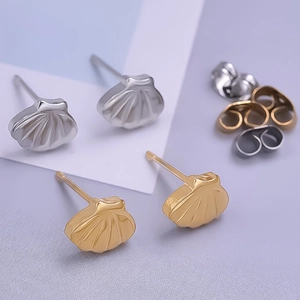 Detailed macro view of gold and silver shell earrings with assorted butterfly backs