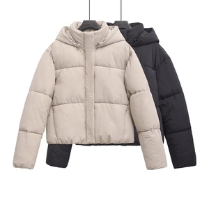 Detailed close-up of hooded winter puffer jackets in beige and black matte fabrics