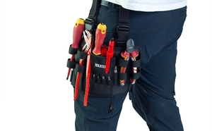 Detail of a durable black nylon leg tool bag worn on waist showing multi-pocket storage