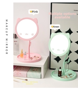Detail of cat-ear desktop makeup mirrors in pink and green with jewelry storage trays