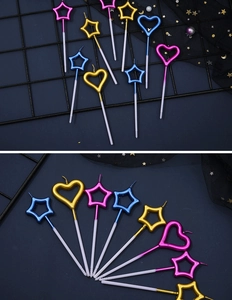 Detailed view of metallic gold, pink, and blue heart and star birthday cake candles