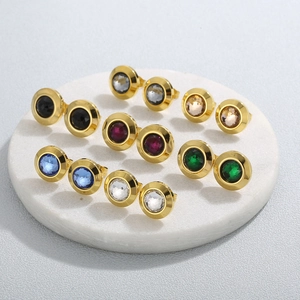 Detail view of colorful round gemstone stud earrings in various shades on stone display