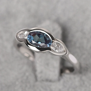Elegant geometric silver ring with oval blue-gray stone and pear-cut side stones