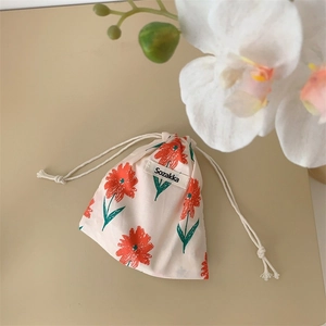 Detailed macro view of small floral cotton drawstring bag with orange flower patterns