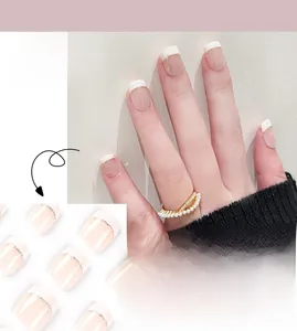 Detail of short French press-on nails with white tips and gold lines for a chic look