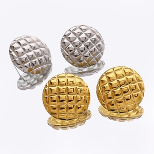 Detailed view of square quilted pattern stud earrings in polished gold and silver finish