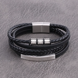 Detail of multi-layer black leather bracelet with braided cord and magnetic steel clasp