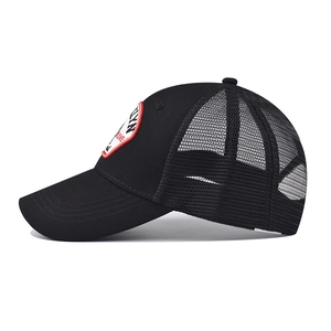 Detail of black mesh trucker hat showing red embroidery patch and breathable netting