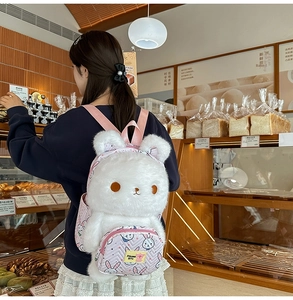 Detail of white plush bunny backpack with pink straps and a zippered front pocket
