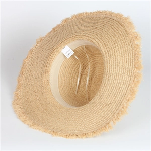 Detail of raffia sun hat featuring frayed edges and adjustable inner sweatband