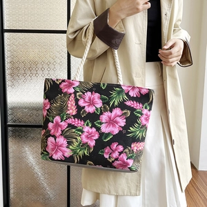Detail of floral canvas tote bag featuring pink hibiscus print and white rope handles