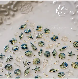Macro detail of 3D ocean themed nail stickers with gold shell and starfish relief