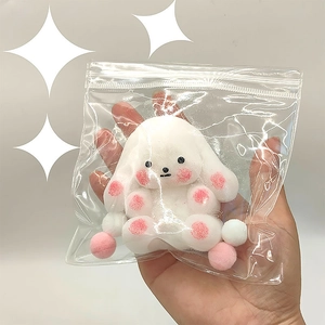 Portachiavi con coniglio di peluche bianco e zampe rosa in una busta trasparente