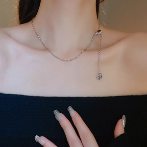 Detail of silver Y-shaped necklace with red teardrop stone on model neckline