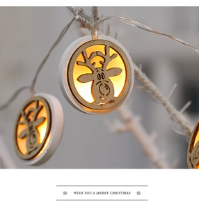 Detail of wooden LED star ornaments with reindeer cutouts on white branches
